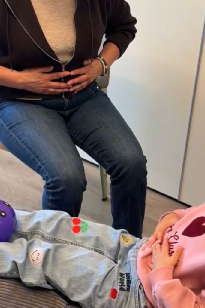 mains sur le ventre de l'enfant pour ressentir l'émotion et travailler avec la respiration